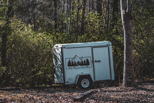 an outhouse in the woods with trees in the background