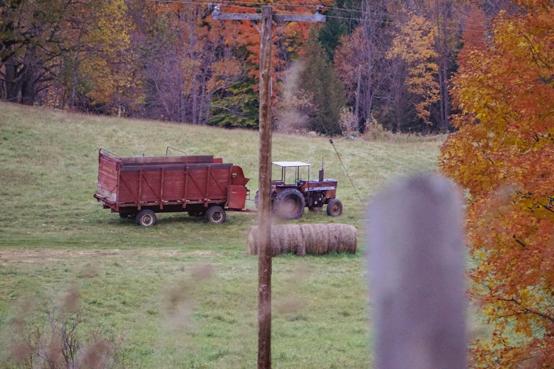 a tractor pulling a bale of hay in a field