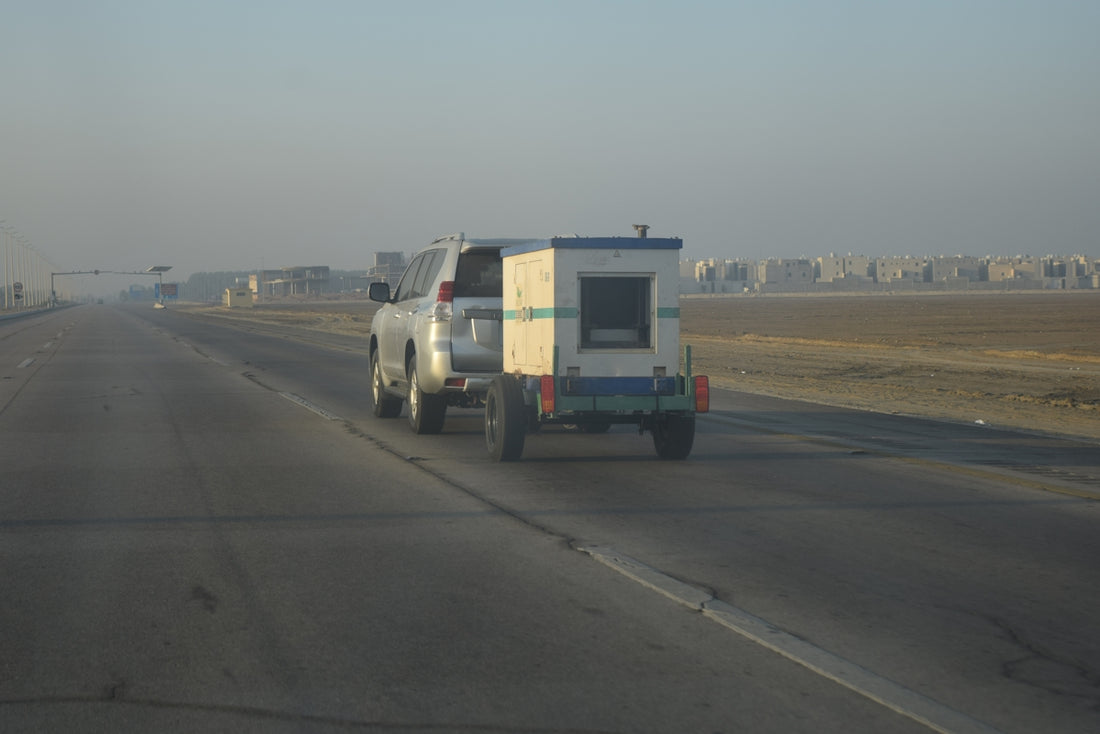 A truck driving down a road with a trailer attached to it