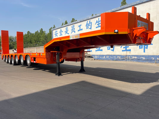 An orange heavy-duty trailer with multiple axles.