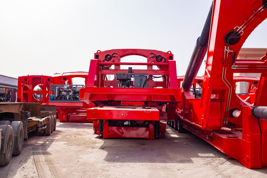 Several large red industrial trailers parked outdoors.