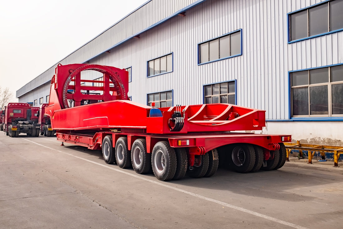 A large red heavy-duty trailer parked outside a building