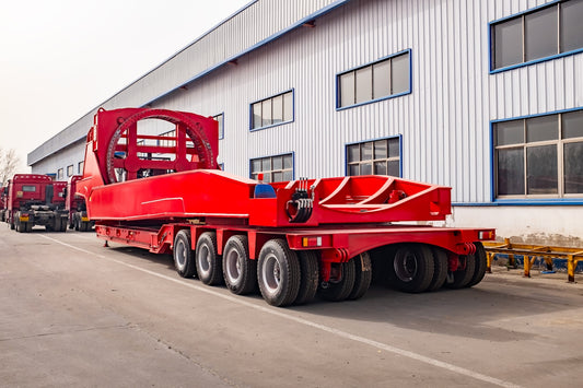 A large red heavy-duty trailer parked outside a building